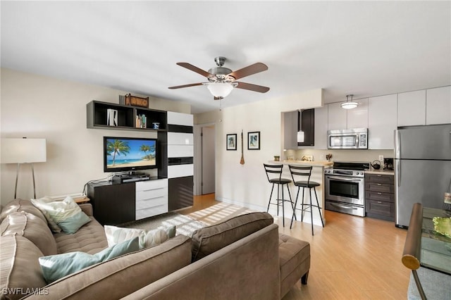 living room with light hardwood / wood-style floors and ceiling fan