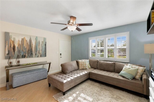 living room with light hardwood / wood-style flooring and ceiling fan