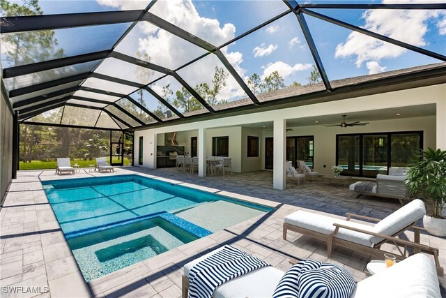 view of swimming pool featuring an outdoor kitchen, a lanai, an outdoor living space, ceiling fan, and a patio