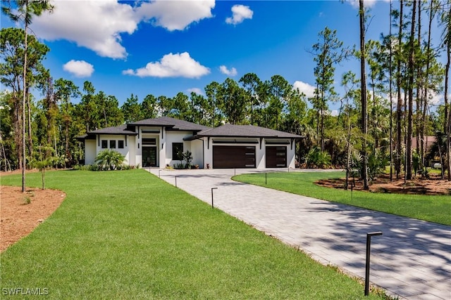 prairie-style house with a garage and a front lawn