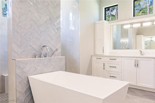 bathroom with vanity, a tub to relax in, and tile walls