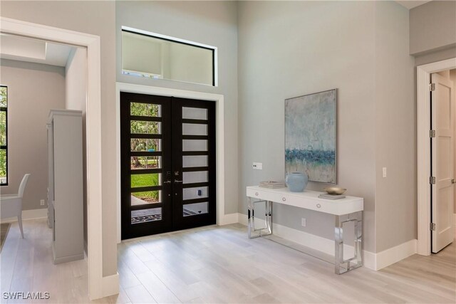 entrance foyer with french doors and light hardwood / wood-style floors