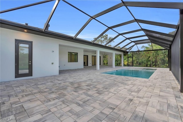 view of pool featuring a patio area, ceiling fan, and a lanai