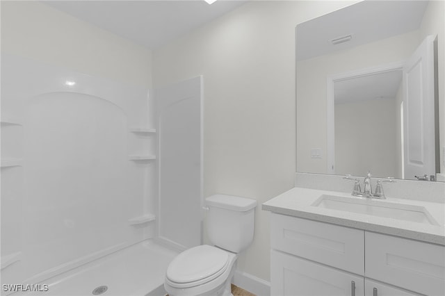 bathroom featuring a shower, vanity, and toilet