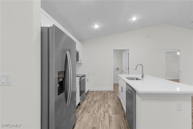 kitchen featuring white cabinetry, sink, stainless steel appliances, vaulted ceiling, and a kitchen island with sink