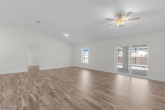 empty room with ceiling fan, light wood-type flooring, and vaulted ceiling