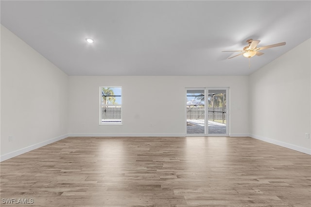 empty room featuring ceiling fan, light wood-type flooring, and a wealth of natural light