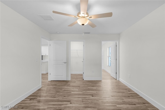 empty room with ceiling fan and light wood-type flooring