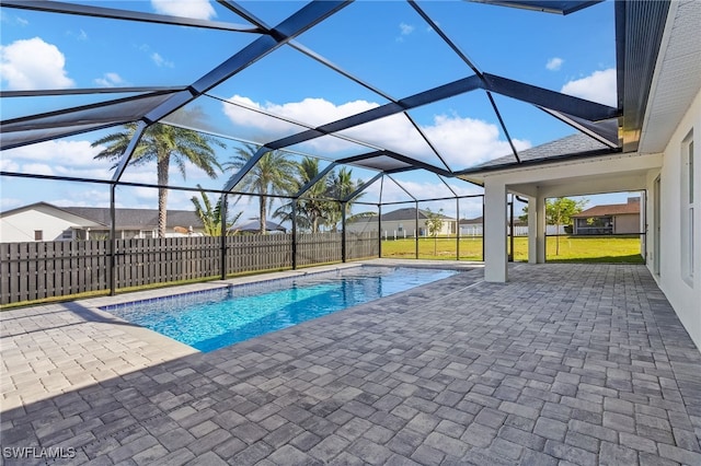 view of pool featuring glass enclosure, a patio area, and a yard