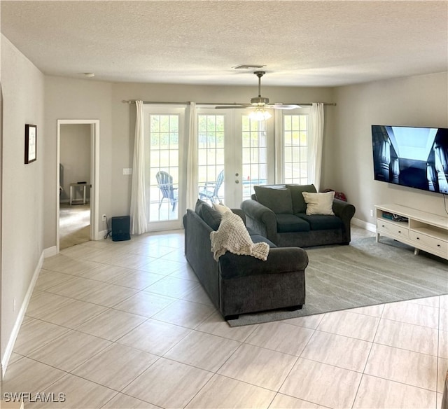 tiled living room with french doors, a textured ceiling, plenty of natural light, and ceiling fan