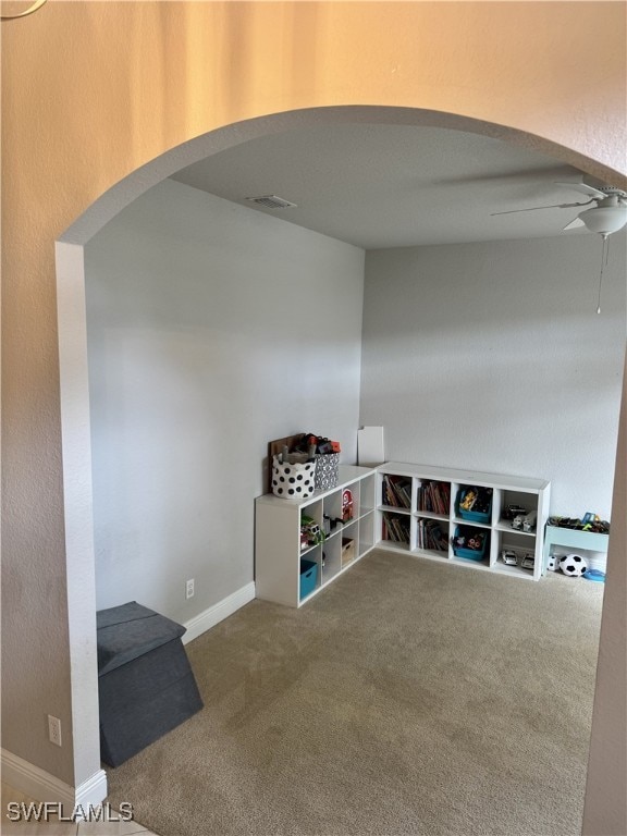 interior space with ceiling fan and carpet