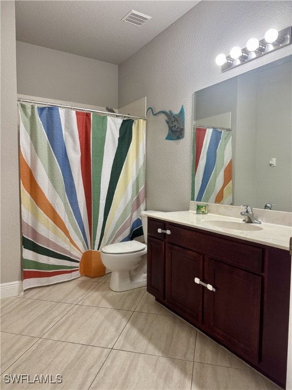 bathroom with tile patterned flooring, vanity, and toilet