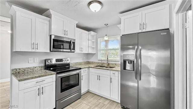 kitchen featuring stainless steel appliances, white cabinetry, and sink