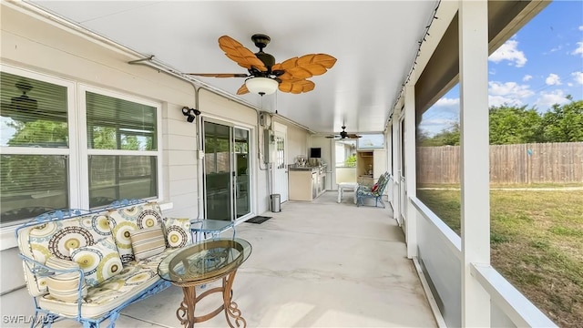 sunroom / solarium featuring ceiling fan