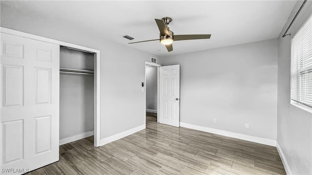 unfurnished bedroom with ceiling fan and a closet