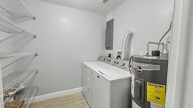 laundry area featuring electric water heater, separate washer and dryer, light hardwood / wood-style flooring, and electric panel