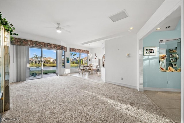 unfurnished living room featuring a water view, light colored carpet, and ceiling fan