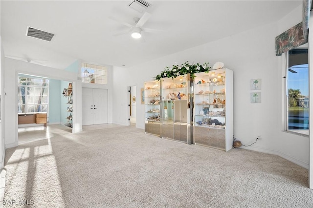 unfurnished living room with ceiling fan and carpet floors