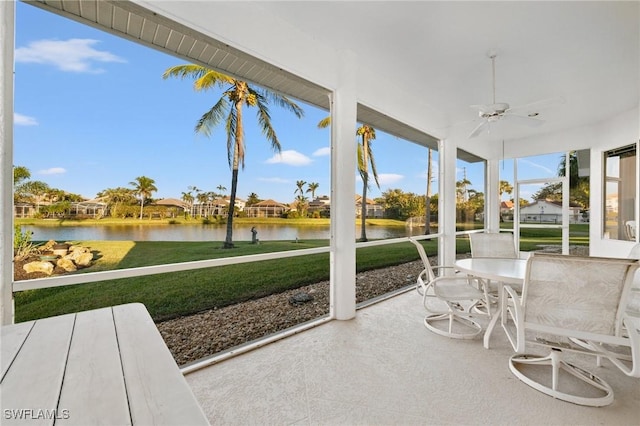 sunroom / solarium featuring a water view and ceiling fan