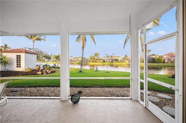 sunroom featuring a water view