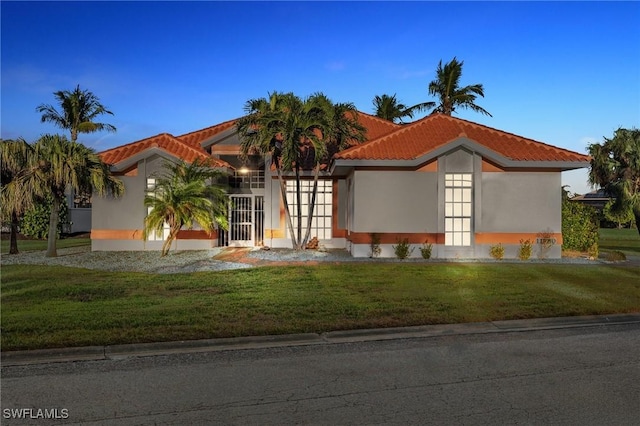 mediterranean / spanish-style house featuring a lawn