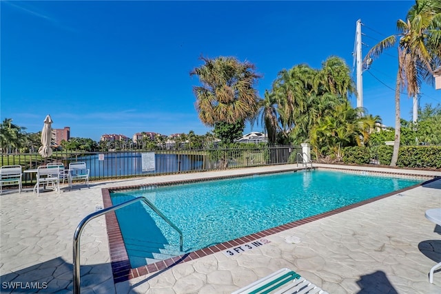 view of pool featuring a water view and a patio