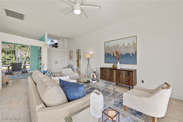 living area featuring carpet, visible vents, and ceiling fan