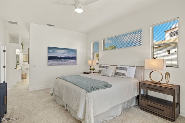 bedroom with visible vents, light colored carpet, baseboards, and a ceiling fan