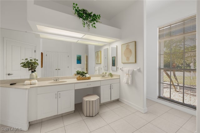 bathroom featuring tile patterned floors, double vanity, baseboards, and a sink