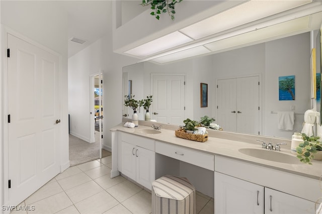 full bath featuring tile patterned floors, visible vents, double vanity, and a sink