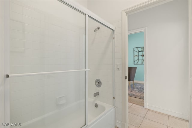 bathroom featuring tile patterned floors, baseboards, and shower / bath combination with glass door