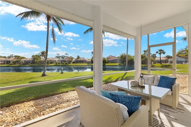 sunroom / solarium with a residential view and a water view