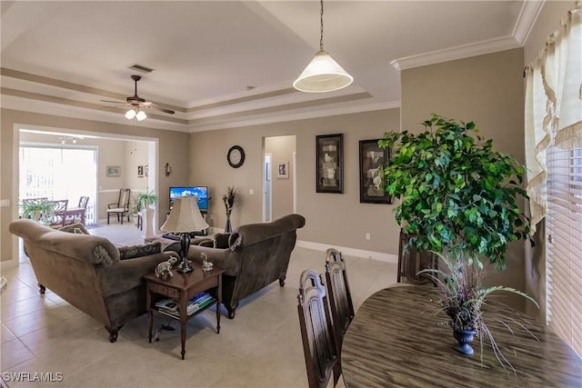 living room featuring light tile patterned floors, a raised ceiling, ceiling fan, and ornamental molding