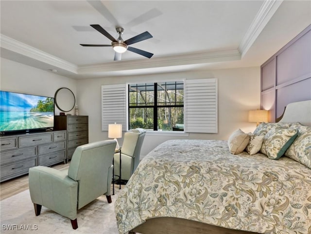 bedroom featuring ceiling fan, a raised ceiling, and crown molding