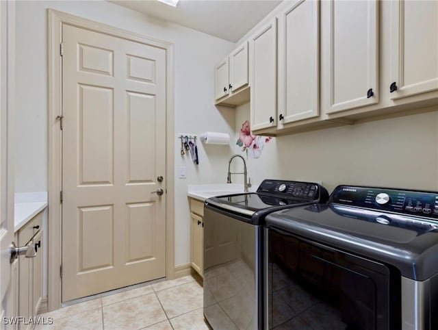 laundry area with separate washer and dryer, sink, light tile patterned floors, and cabinets