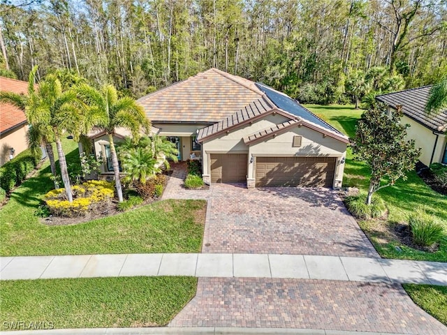 view of front of property with a garage and a front lawn