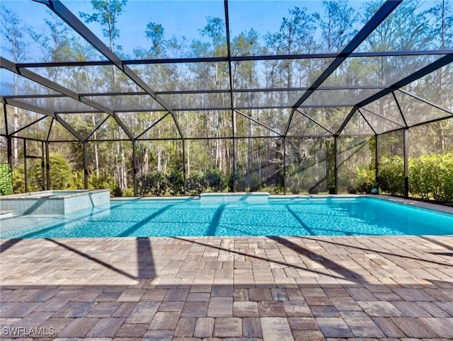 view of pool with a patio, a hot tub, and a lanai