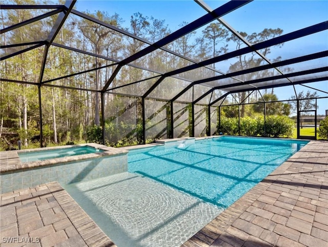 view of pool featuring a patio area, a lanai, and an in ground hot tub