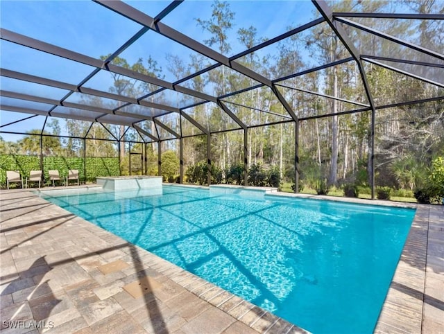 view of swimming pool featuring glass enclosure and a patio area