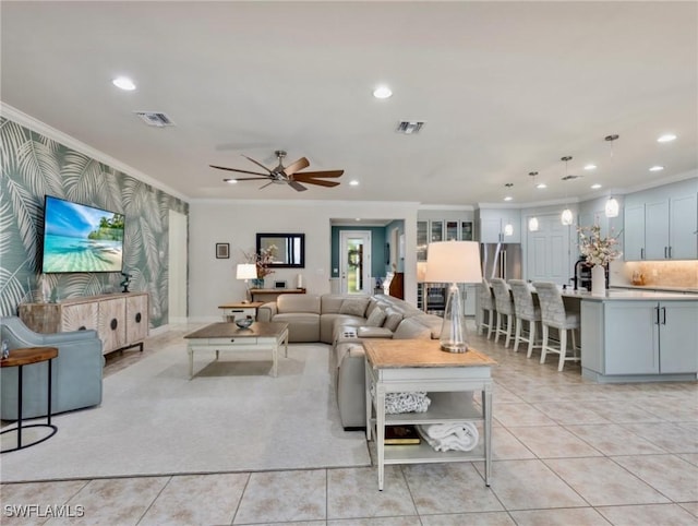 tiled living room featuring ceiling fan and crown molding