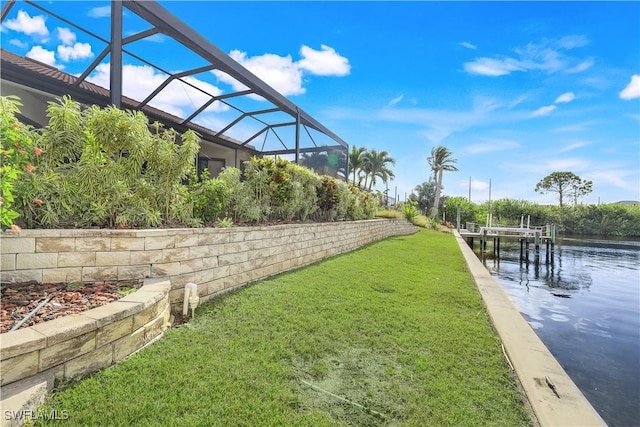 view of yard with a lanai and a water view