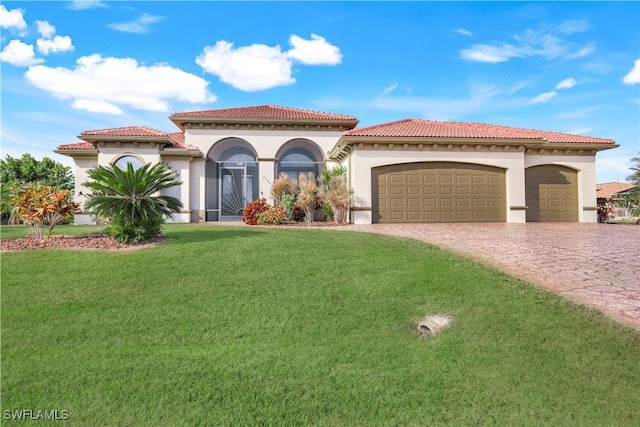 mediterranean / spanish home featuring a garage and a front yard