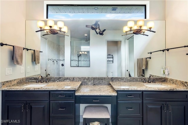 bathroom with a tile shower and vanity