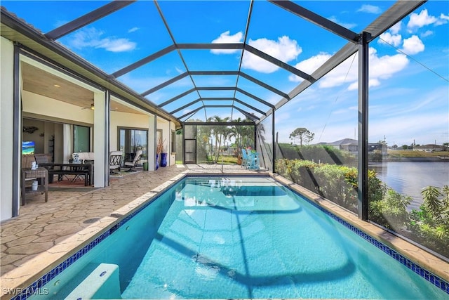 view of pool featuring outdoor lounge area, ceiling fan, a water view, glass enclosure, and a patio