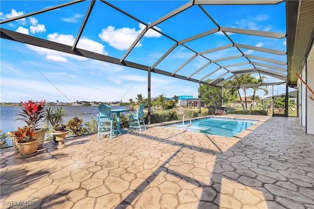 view of pool with glass enclosure, a patio area, and a water view