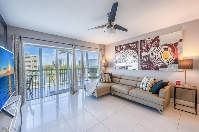 living area with a ceiling fan, a view of city, and light tile patterned floors