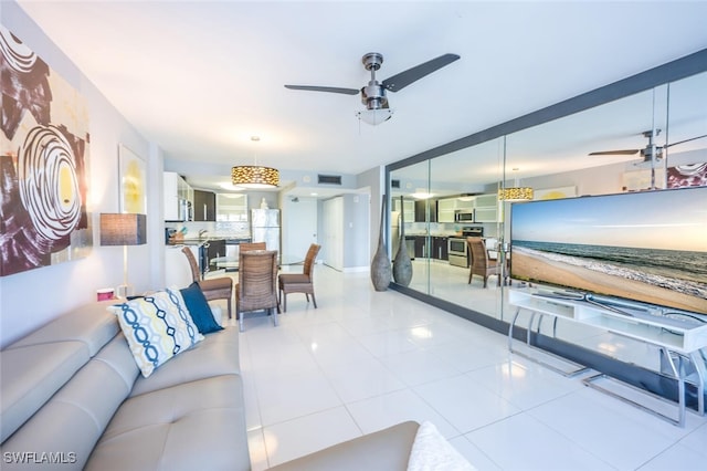 tiled living room featuring visible vents and ceiling fan