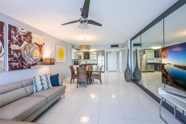 living area featuring a ceiling fan, visible vents, and light tile patterned floors