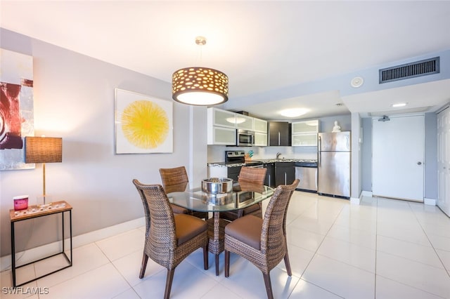 dining area with light tile patterned floors, visible vents, and baseboards