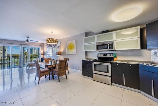 kitchen with stainless steel appliances, hanging light fixtures, decorative backsplash, open shelves, and glass insert cabinets